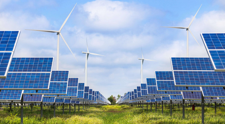 Solarfeld mit doppelseitigen Paneelen und Windkraftanlagen im Hintergrund bei bewölktem Himmel